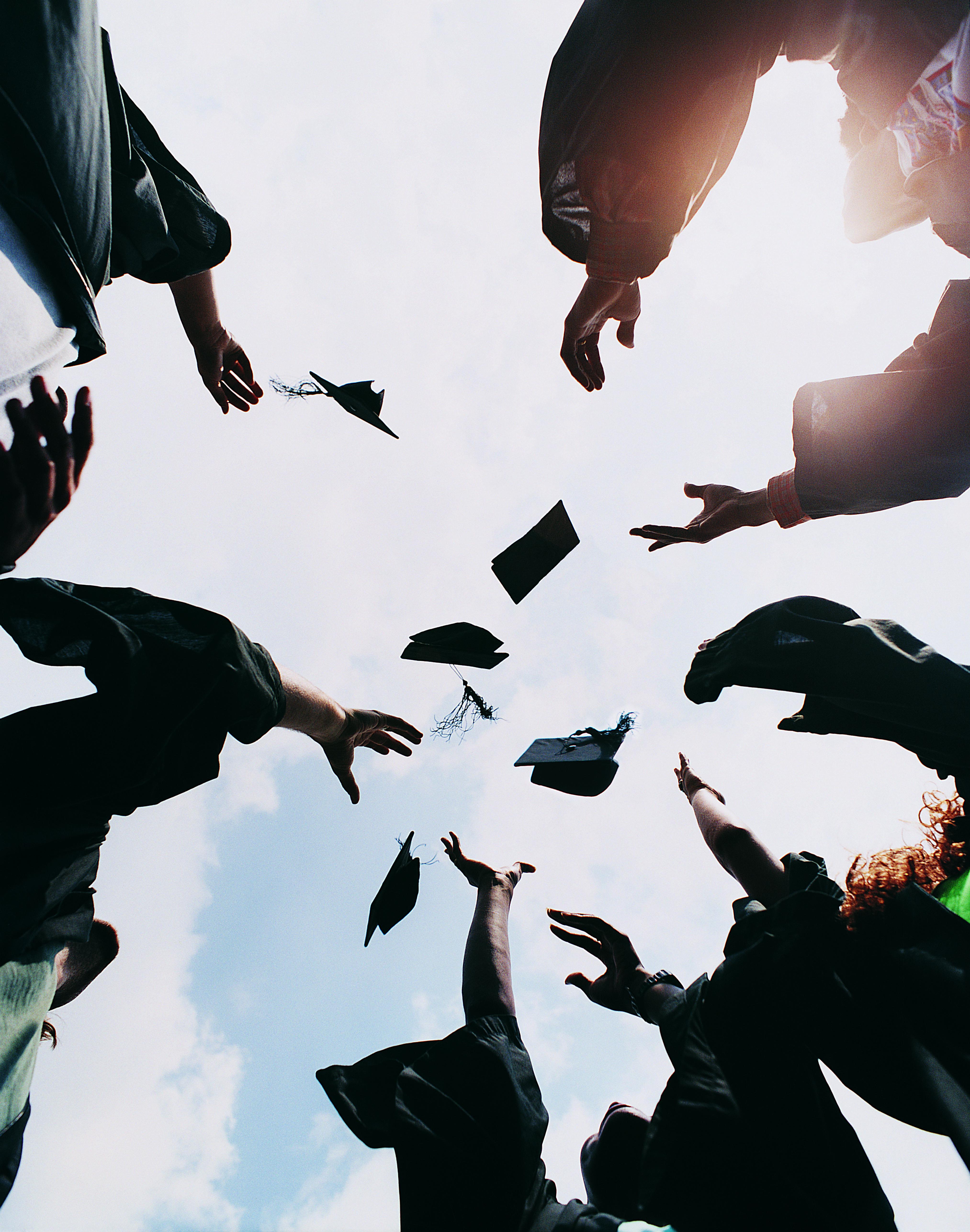 Five Students Throwing Their Mortar Boards in the Air at Graduation