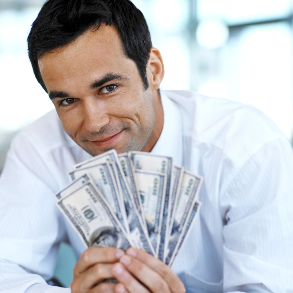 front view portrait of businessman holding a stack of American dollar notes
