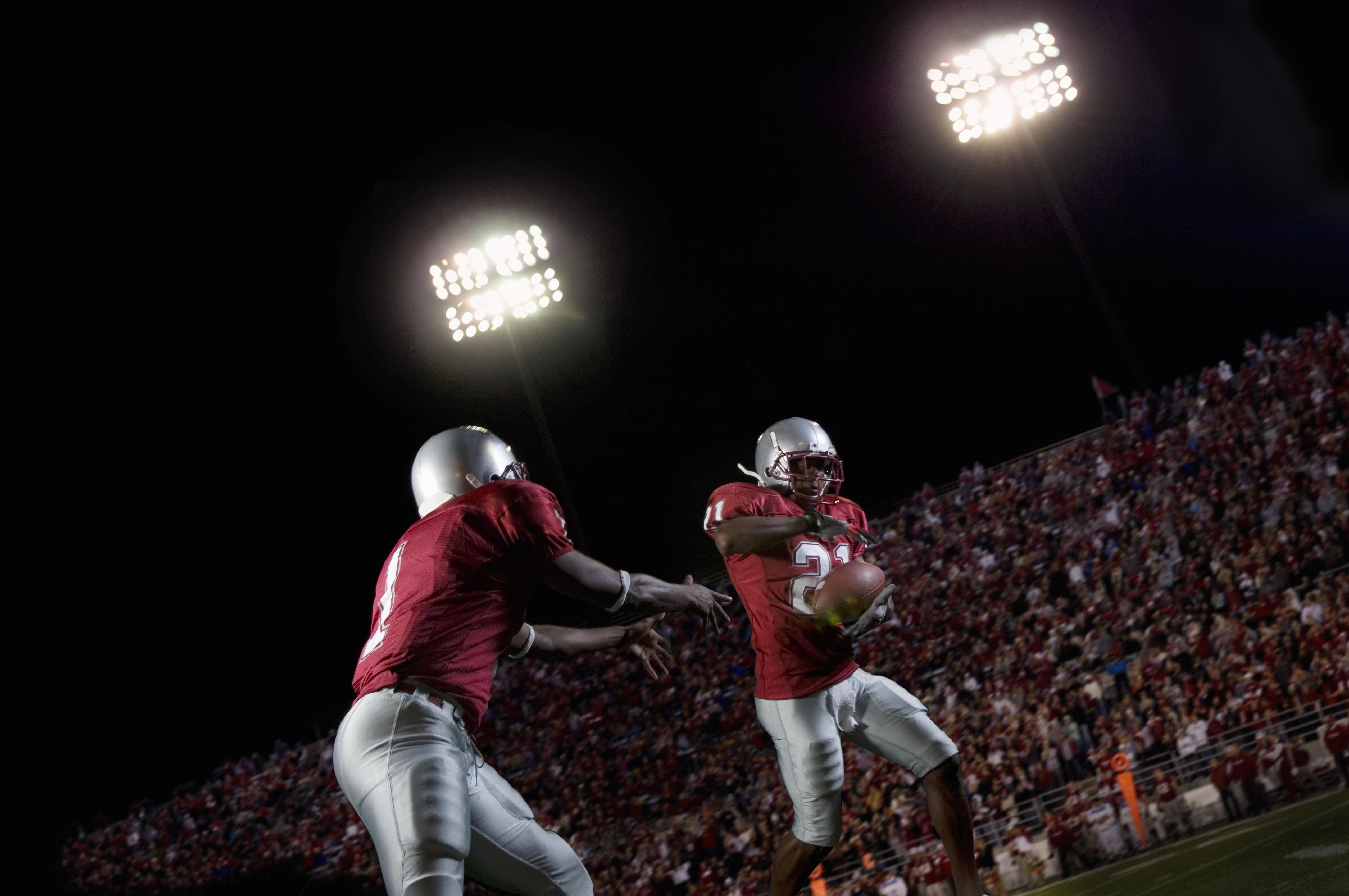 Male football players passing football