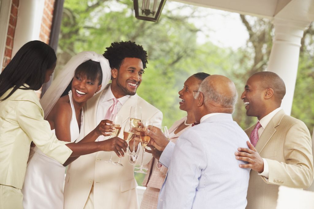 African American newlyweds toasting with family