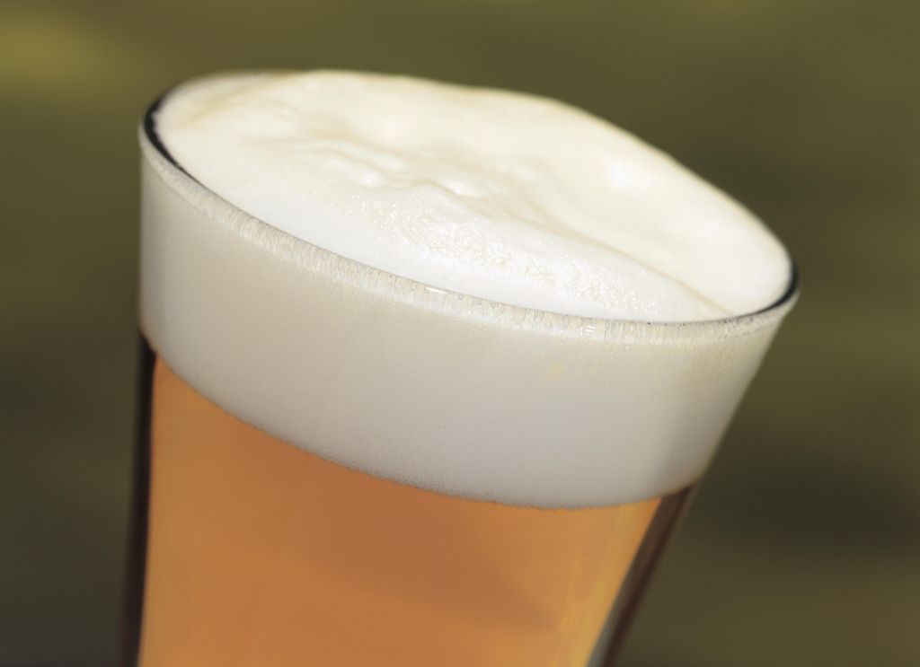 close-up of a head of beer in a glass