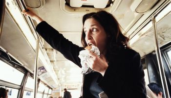 Woman eating hamburger on bus
