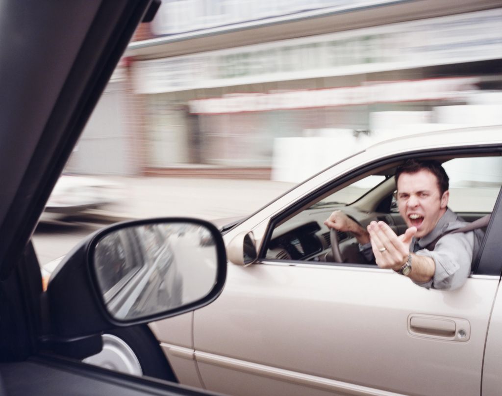 Man in car gesticulating angrily at another driver (blurred motion)