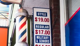 barber pole and sign in front of barber shop