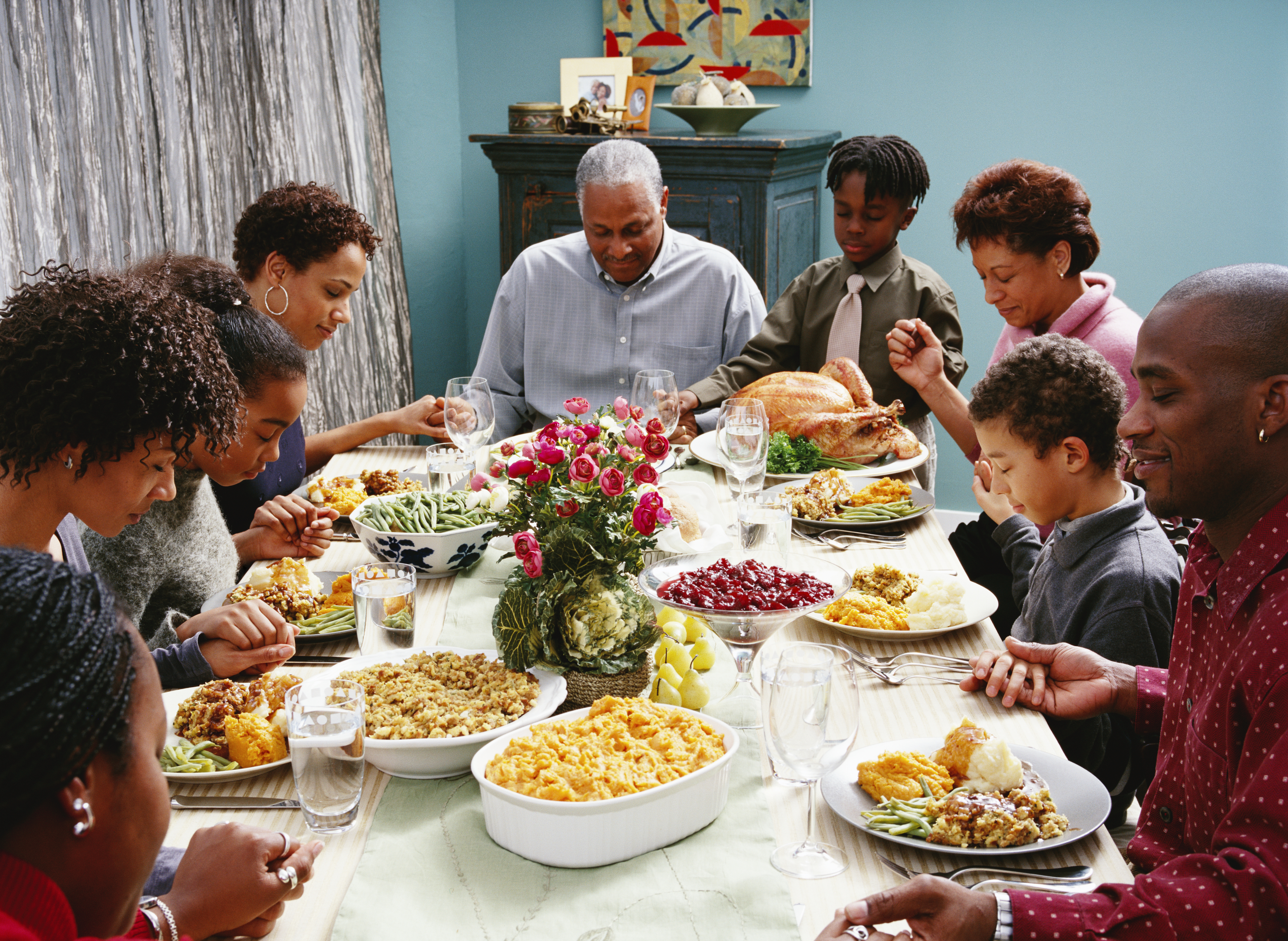 Family Saying Grace at Thanksgiving Dinner