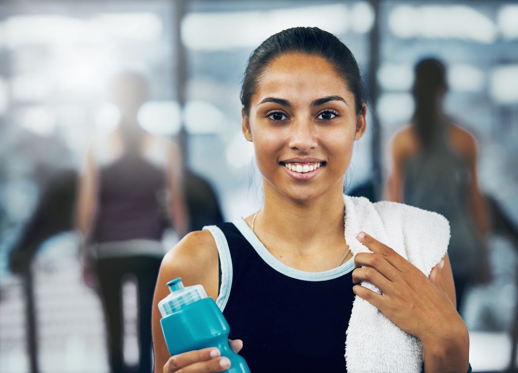 Beautiful young woman smiling after exercising at gym