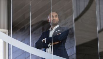Serious, CEO businessman standing at office window