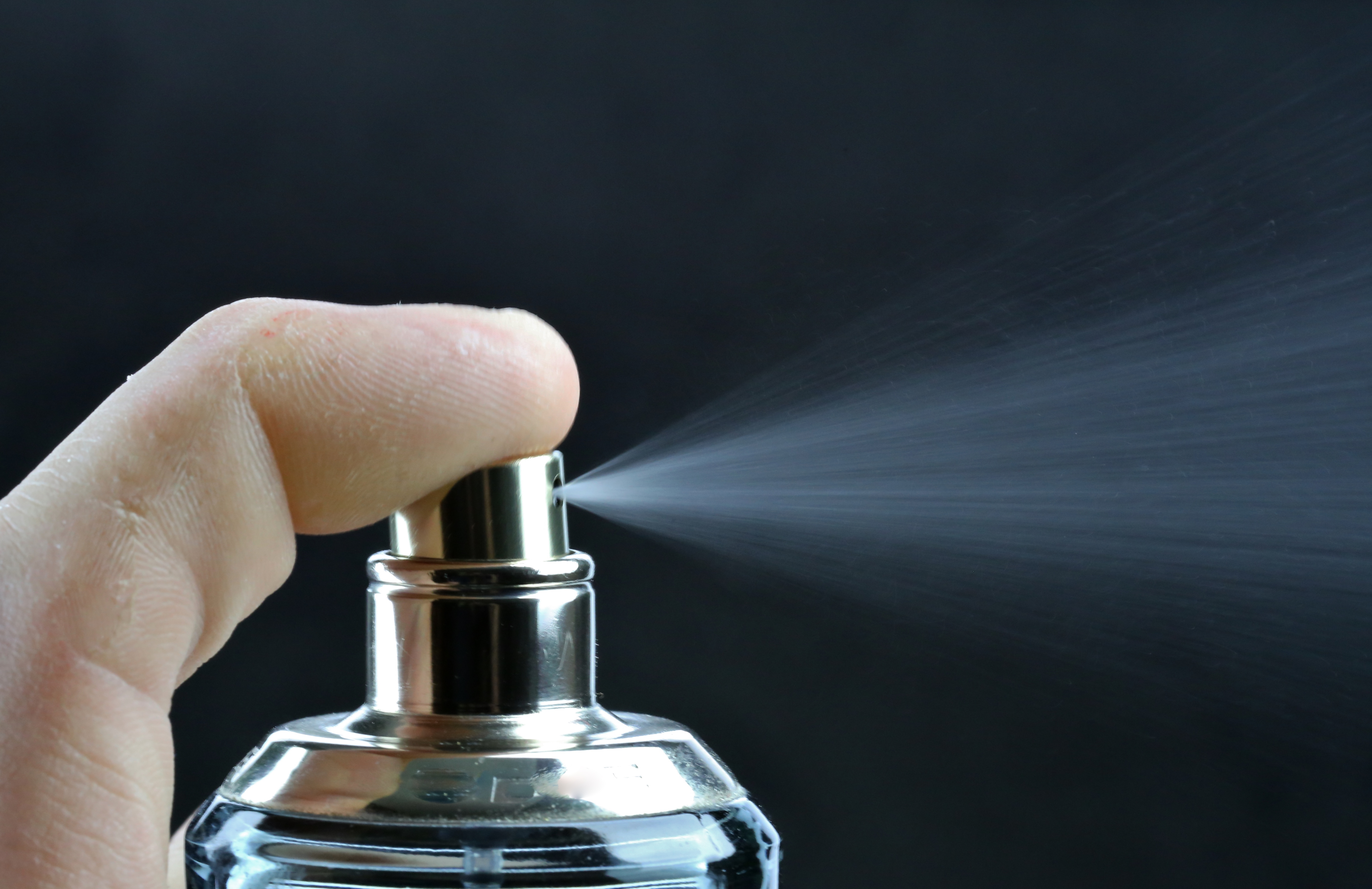 Spray of scented cologne from a perfume bottle