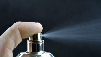 Spray of scented cologne from a perfume bottle