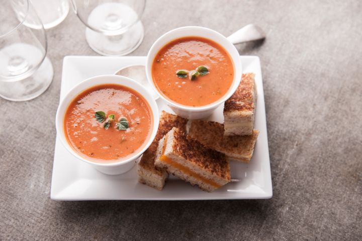 Sliced grilled cheese sandwich and tomato soup
