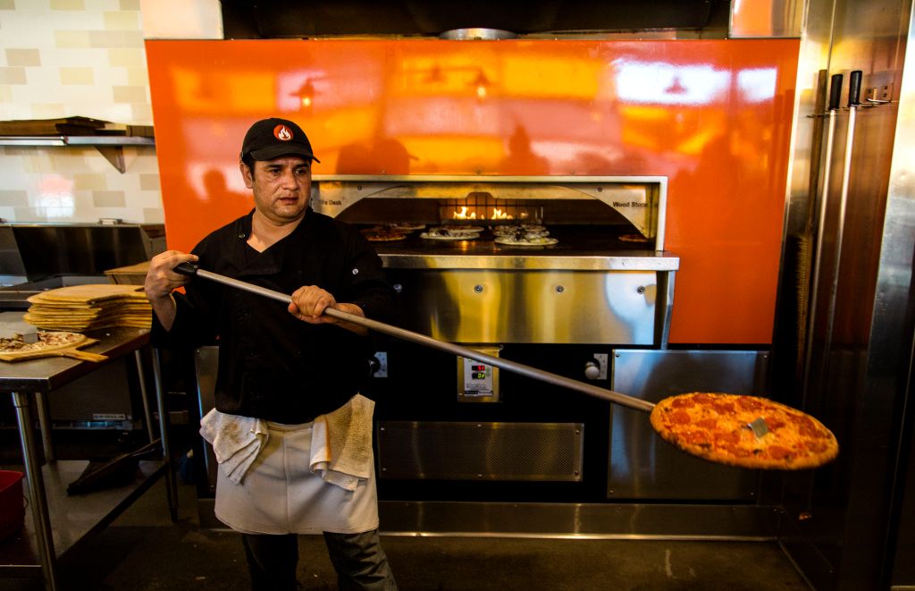 PASADENA, CA - FEBRUARY 21, 2014 - Pizza cook Jorge Agundez, cq, taking a pizza out of the oven at B