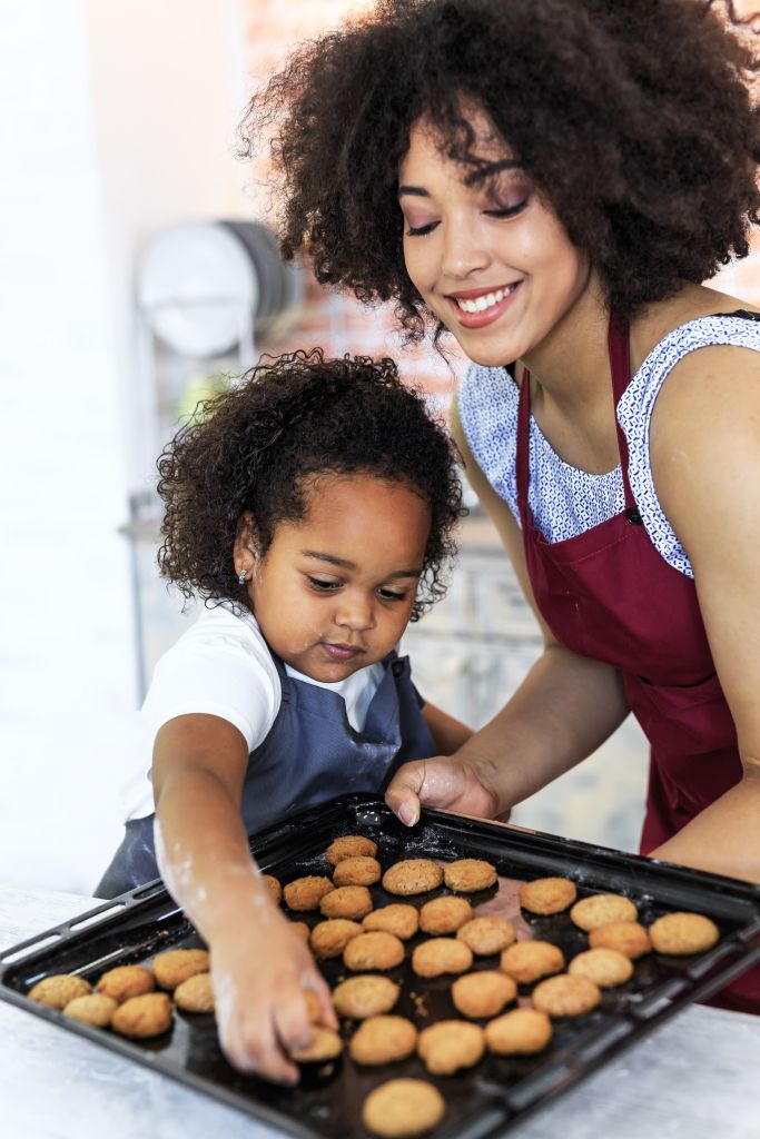 Cute little girl baking at home with mom