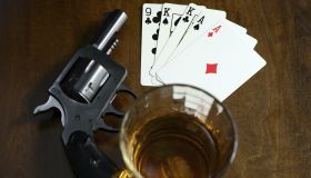 old west poker game with pistol, alcohol and a winning hand