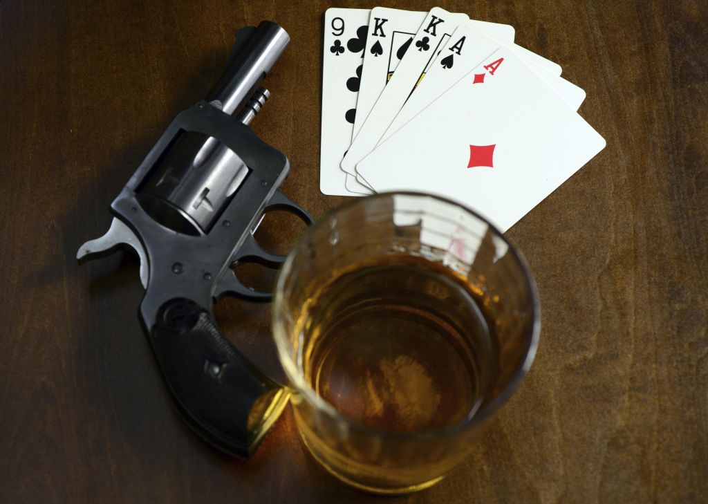 old west poker game with pistol, alcohol and a winning hand