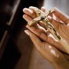 Hands in Church Holding Crucifix