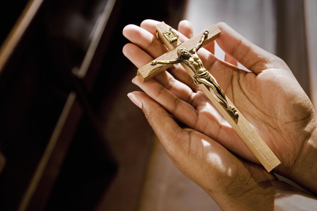 Hands in Church Holding Crucifix