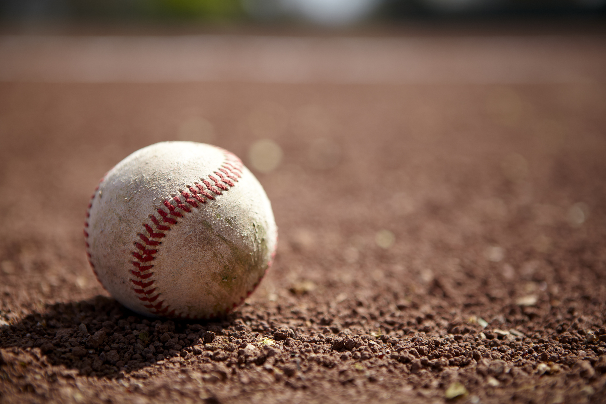 Still life of a baseball on baseball diamond