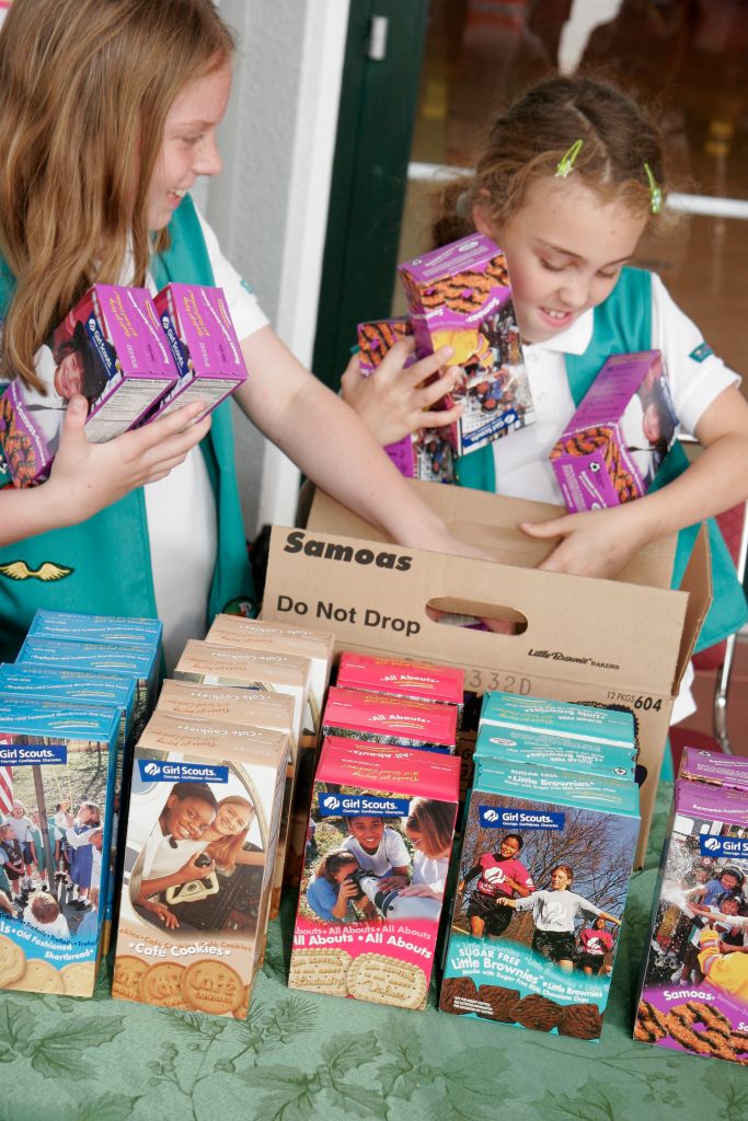 Girl Scouts selling boxes of cookies