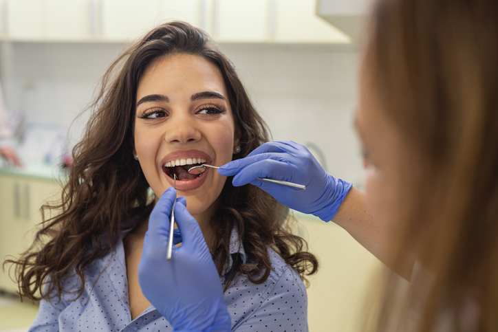 Young Woman is Receiving Medical Treatment At The Dentist's Office