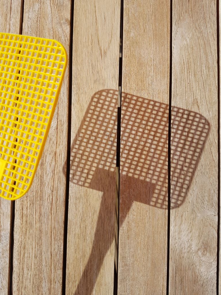 High Angle View Of Yellow Fly Swatter Over Wooden Table