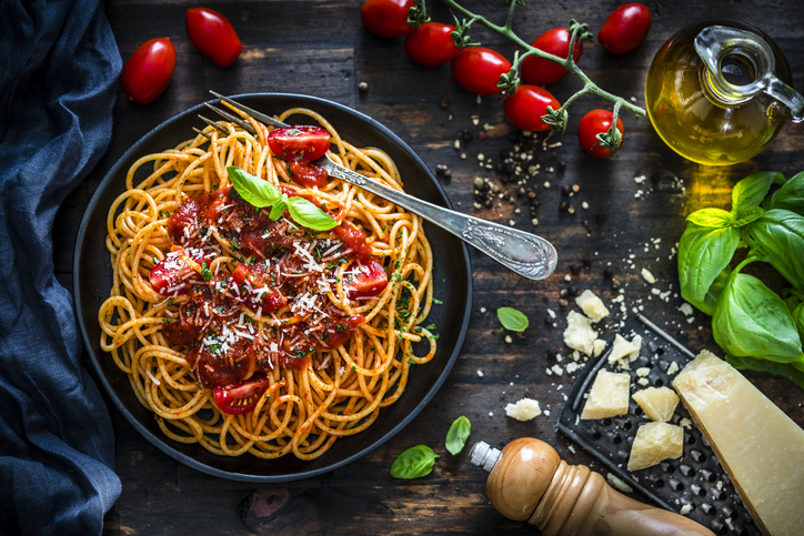 Spaghetti with tomato sauce shot on rustic wooden table