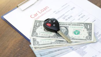 Car loan application with car keys and money