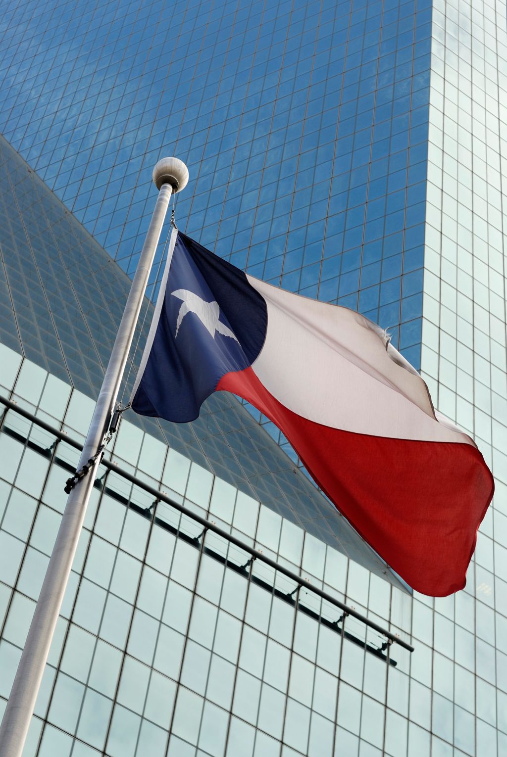 Texas flag against glass office building