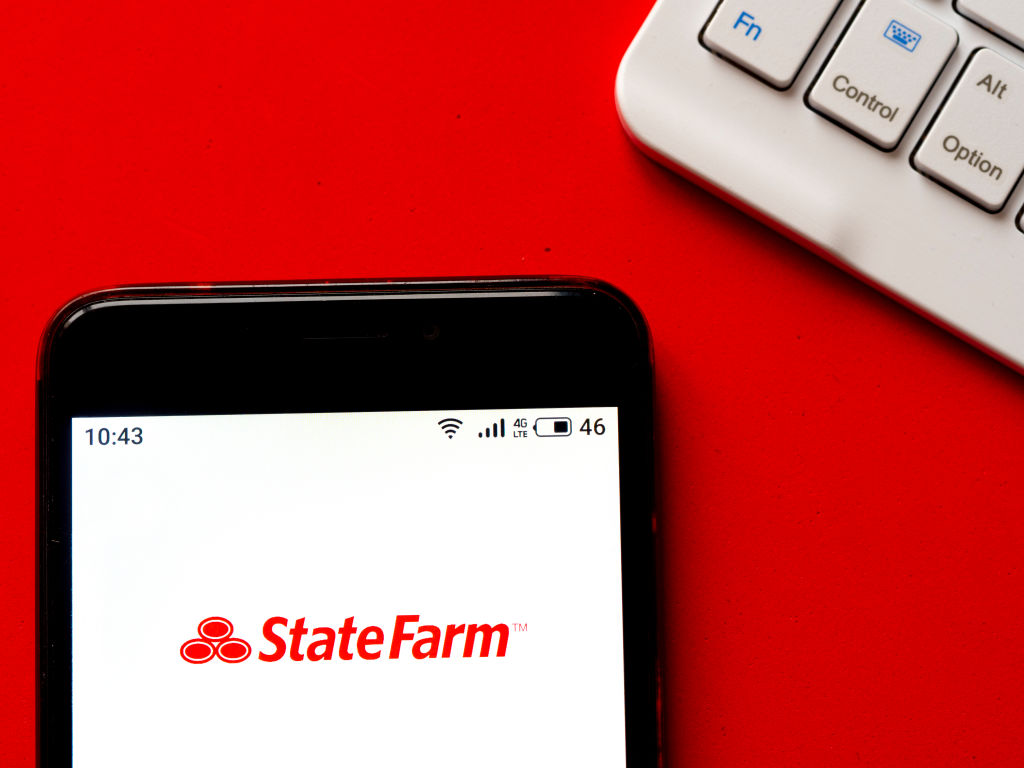 In this photo illustration a State Farm logo seen displayed...