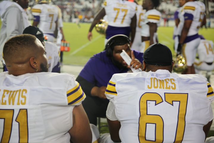 PV Coach and football players on sidelines