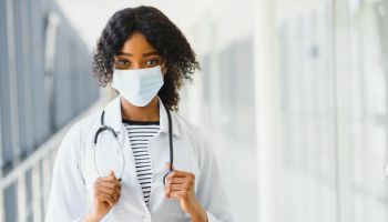 female doctor with stethoscope on hospital corridor holding clipboard with an operating room at the background ,Healthcare and medical concept,selective focus.