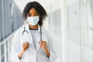 female doctor with stethoscope on hospital corridor holding clipboard with an operating room at the background ,Healthcare and medical concept,selective focus.