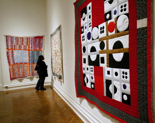 A visitor looks at the "The Quilts of Ge