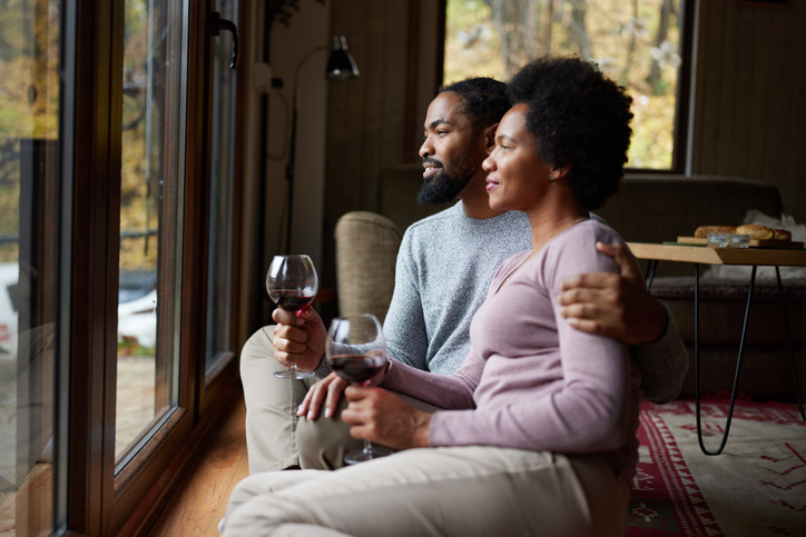 Happy black couple enjoying in wine at home.