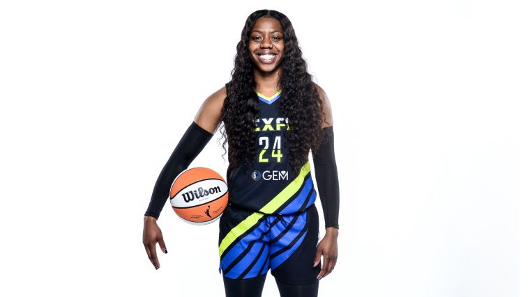 Arike Ogunbowale posing in Blue Dallas Wings G.E.M Jersey