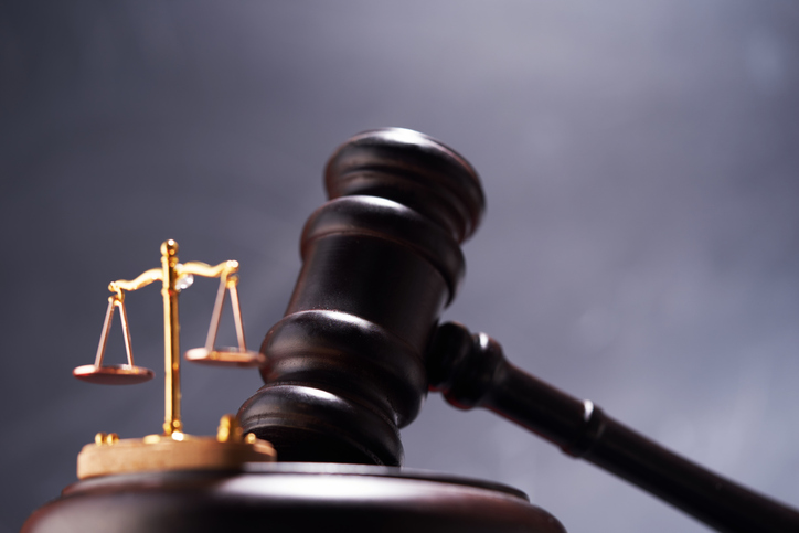 small libra scale and gavel hammer against chalkboard