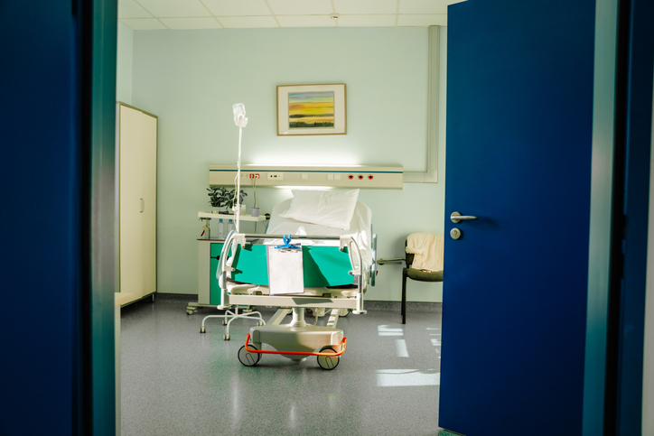 Ready hospital bed: empty medical ward with bed IV drip stands and electronic monitoring devices