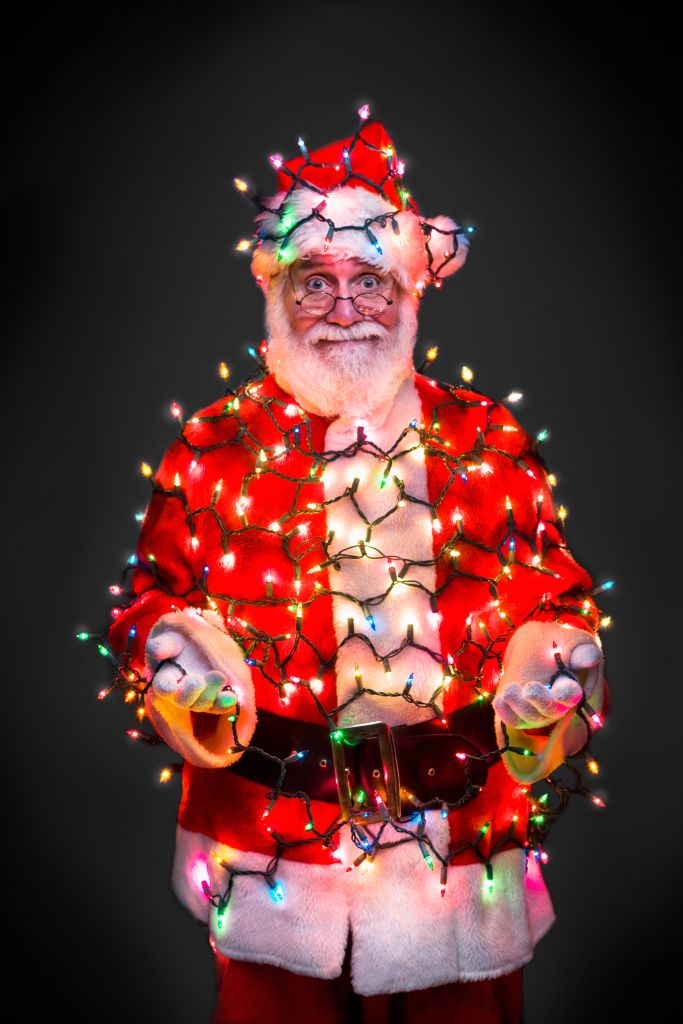 Santa Claus wrapped in Christmas lights