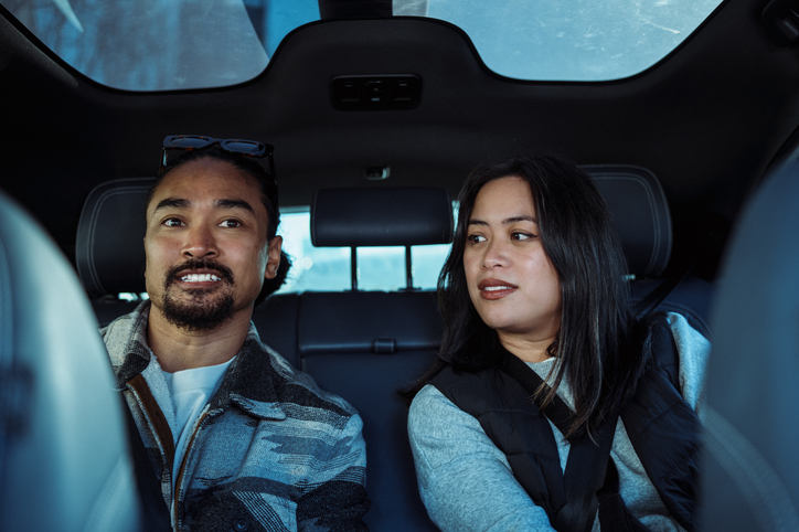 Couple riding in back seat of autonomous driverless taxi