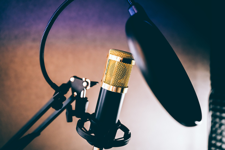 A sound recording studio microphone set up against brown background