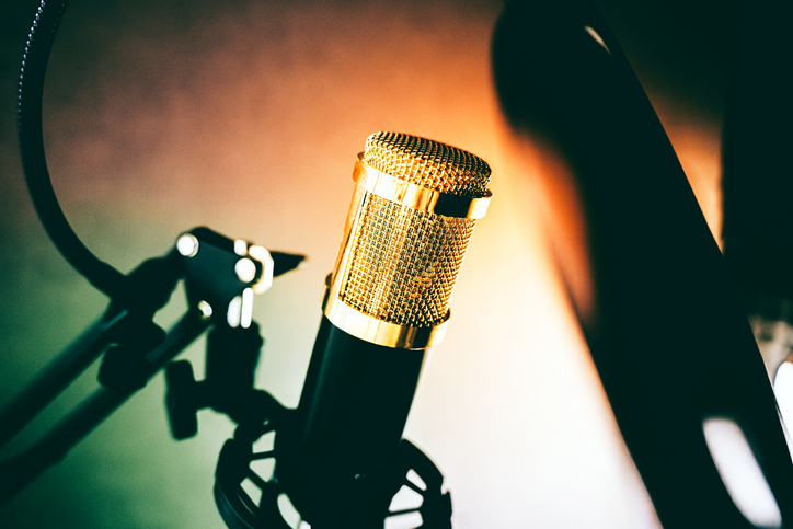 A sound recording studio microphone set up against brown background