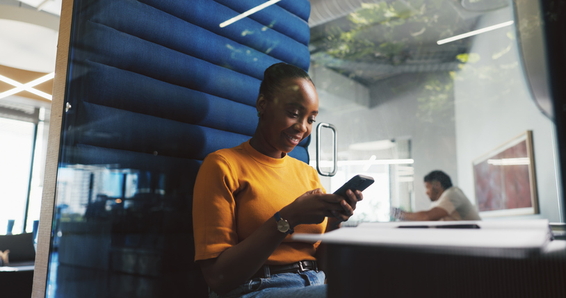 Phone, pod and typing with designer woman in office for project feedback, pot or update. App, communication and text message with employee in cubicle of design workplace for planning or research
