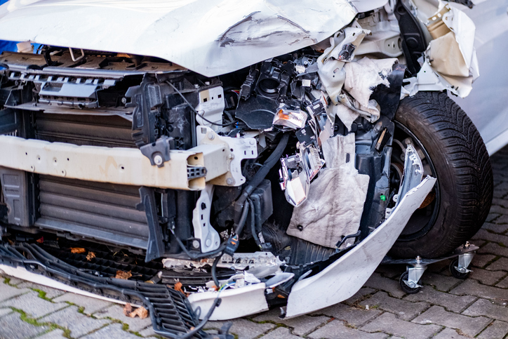 heavily wrecked car close-up, severely damaged car bumper and hood after major accident, Huge dent in car body, reckless driving, tire intact insurance case, repairs needed after serious collision