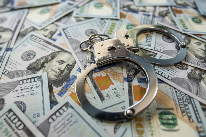 Handcuffs on dollar bills symbol of corruption and financial crime