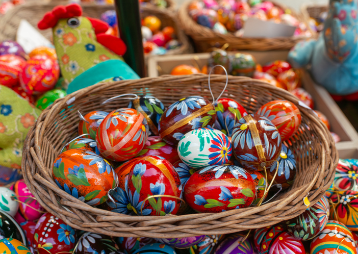 Wicker basket with painted Easter eggs at festive market stall