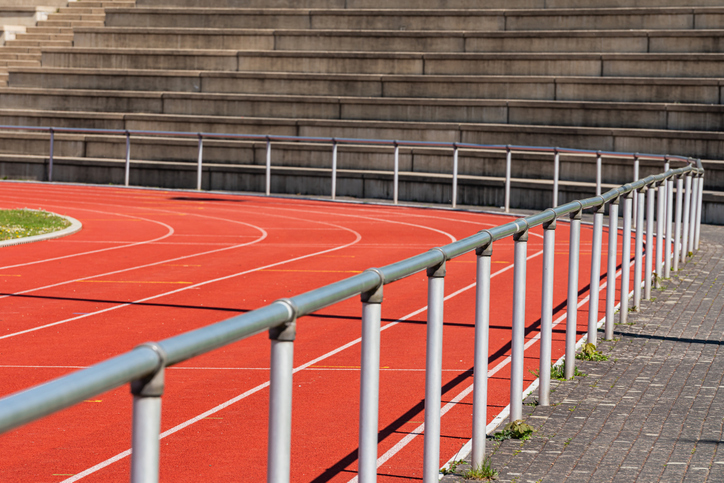 Track and field stadium with red running track and seating area