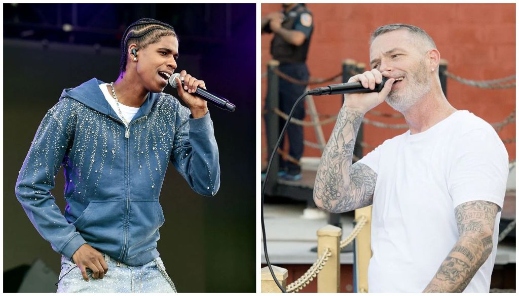 Two musicians performing on stage, one with braided hair singing into a microphone, the other with a beard and tattoos singing into a microphone.